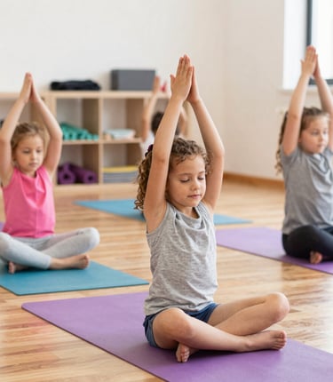 Children happily practicing yoga poses together in a bright, colorful studio.