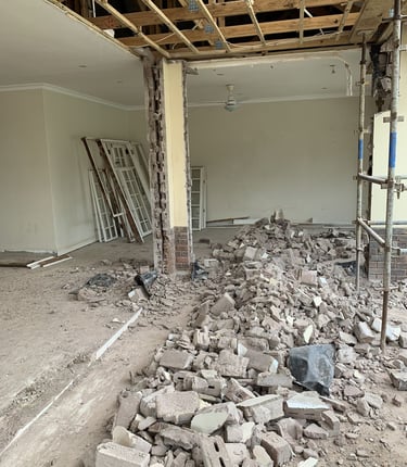 Mur intérieur démoli, gravats au sol et plafond ouvert – réaménagement complet d’un espace de vie