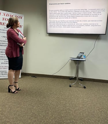 a woman in a red jacket standing in front of a presentation screen