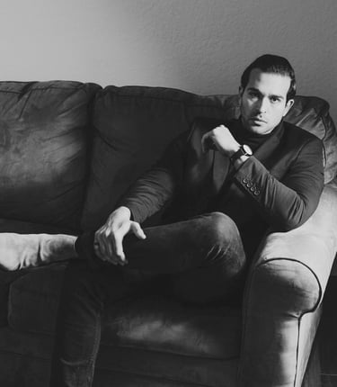 a well dressed man who knows how to plan an excellent date sitting on a sofa 