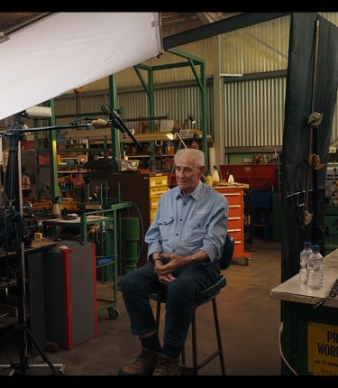 a man under a light modifier scrim while camera films