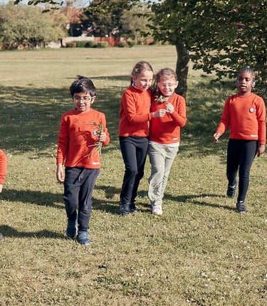 Young members of a Squirrel Dray enjoying the outdoors, looking at nature in the sunshine.