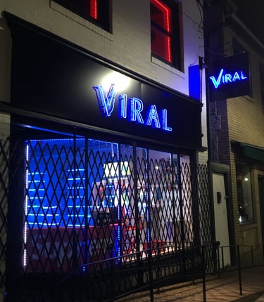 a storefront of a storefront door with a neon sign that says viral