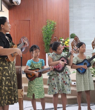  Female teacher and little girls performing ukelele
