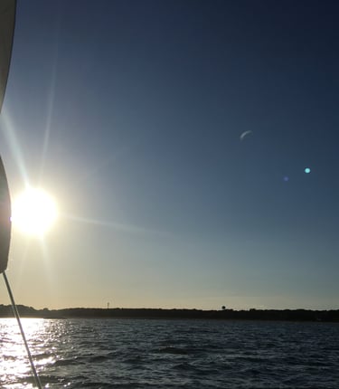 Sunset over water on a buzzards bay charter from a sailboat in Dartmouth Massachusetts