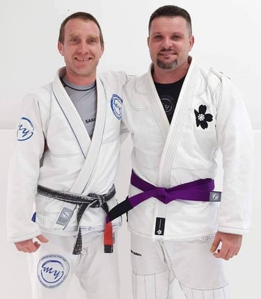 two men standing next to each other in a white room