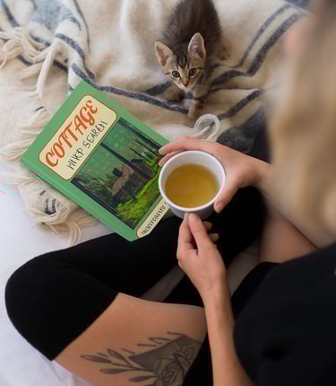 Cozy scene featuring Debas Direct word search puzzle book and coffee cup on soft blanket.
