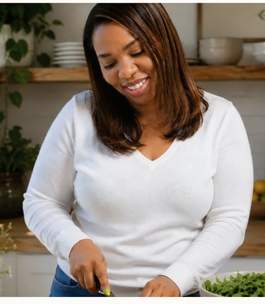 A smiling woman preparing a healthy salad with fresh greens in a bright, modern kitchen.