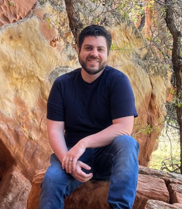 Christopher Carpenter sitting on a rock formation in the Utah mountains.