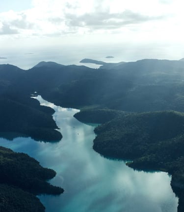 Aerial view of lush green tropical islands and turquoise ocean water in a scenic coastal landscape.