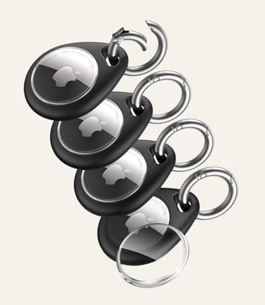 Set of four Apple AirTags in black protective keychain cases with silver carabiner rings.