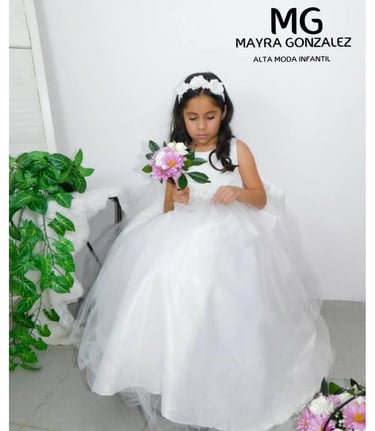 Niña pequeña con un vestido blanco de tul para niña de flores, sosteniendo un ramo.