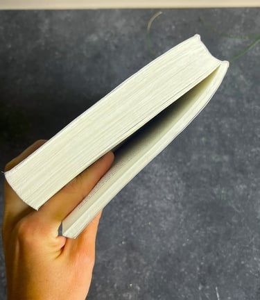 Een gesloten boek in de hand, wijsvinger er tussen om het laatste hoofdstuk te markeren