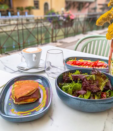 une table avec brunch au bord du Lac d'Annecy avec café, fruits frais, pancakes