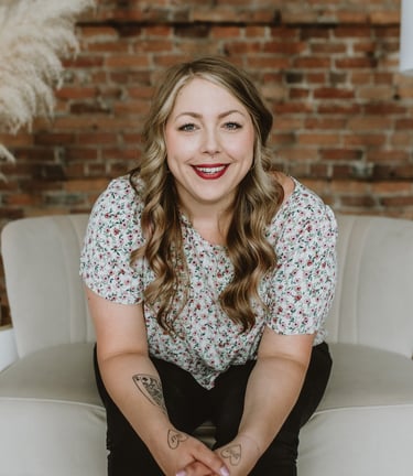 a woman smiling while sitting on a comfy white chair