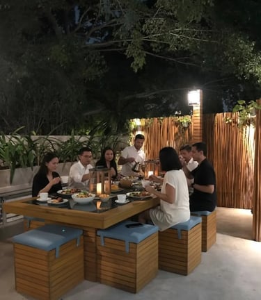a group of people sitting at a table with food
