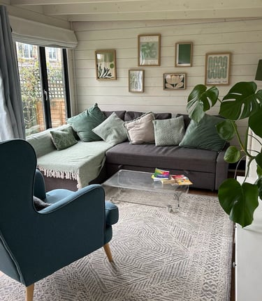 Calm counselling space with a sofa and armchair, plant and soft furnishings
