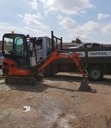 mini digger parked in front of a pickup truck in halesowen