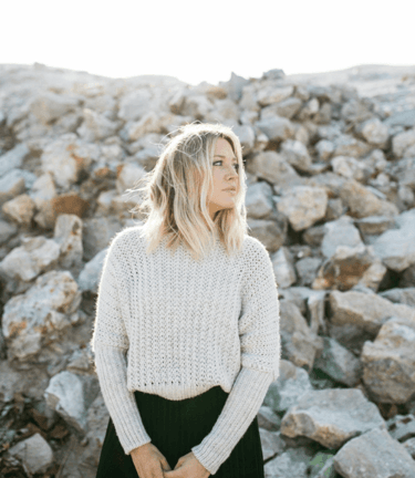 a woman in a white sweater and black skirt