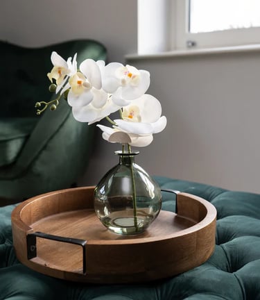 a vase with flowers in a vase on a tray orchid