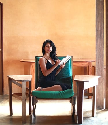 Jungle Flower sitting in a comfy custom built wooden chair, writing stories and poetry.