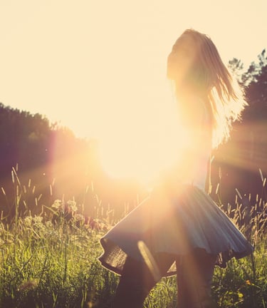Woman in sunlight outdoors signifying soft energetic balance