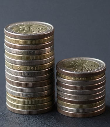stacked round gold-colored coins on white surface