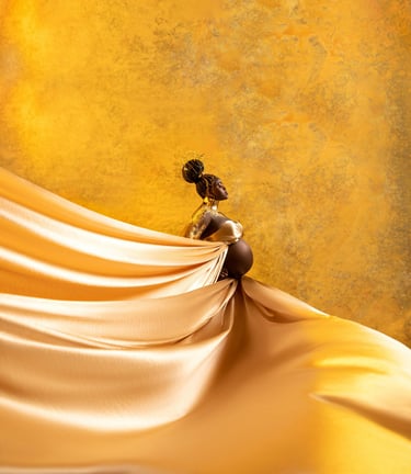 Femme noire enceinte se tenant debout drapée d'un tissus or sur fon doré