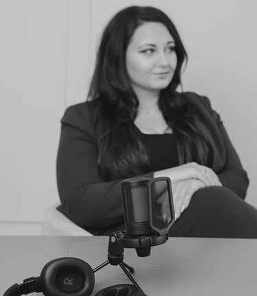 Professional condenser microphone and headphones on a table during a studio podcast recording session.