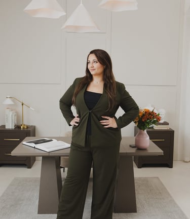 Professional businesswoman in olive green suit posing in modern office studio.