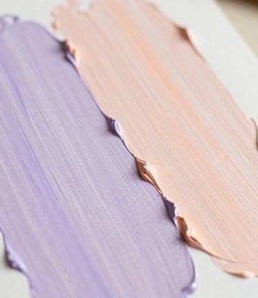 A close-up of paint texture on canvas, soft pastel colors of lavender and peach, bright natural daylight, shallow depth of field