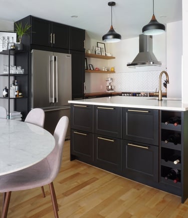 a black kitchen with a marble tulip table and chairs