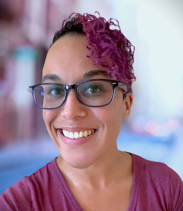 a woman with glasses and a purple shirt