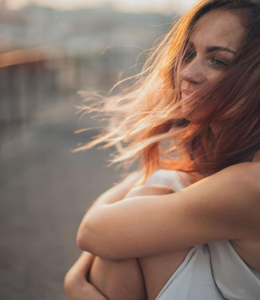 a woman with red hair and a white dress