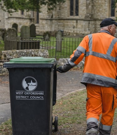 A council worker wearing PPE collecting a bin 