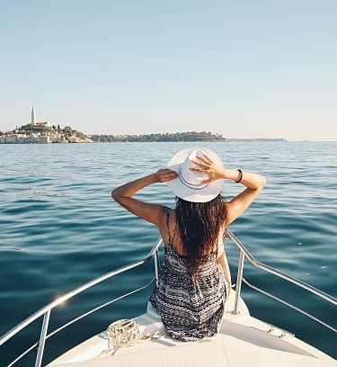 Una mujer con sombrero sentada en un yate