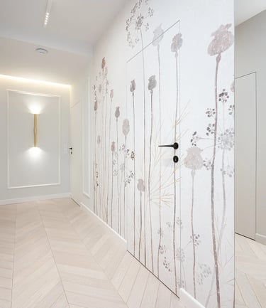 Jasny korytarz z jasną podłogą, drzwiami i ścianą z roślinną tapetą oraz kinkietami.