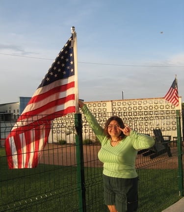 A girl next to a USA flag taking a picture 