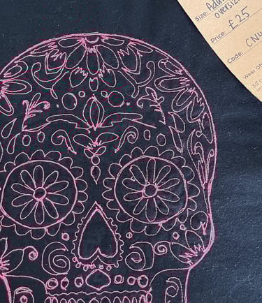 a pink skull on black tshirt lucky threads tag on it