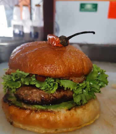 Hamburguesa de ternera gourmet con lechuga fresca y un chile a la parrilla en un pan brioche tostado