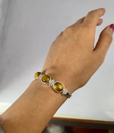a woman's handmade bracelet with a tiger eye