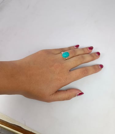 a woman's hand with a turquoise ring on her finger