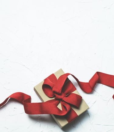 a gift box with a red ribbon tied to it