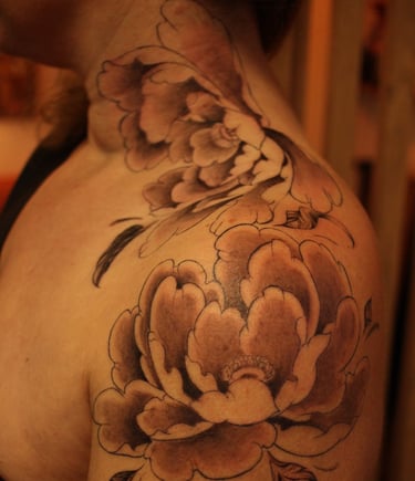 pivoines japonaises tatouées sur l'épaule d'une cliente de Minuit Tattoo
