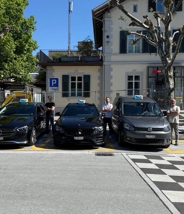 Drei Taxiautos. Ein grauer VW Caddy und zwei schwarze Mercedes E-Klassen samt Taxifahrer