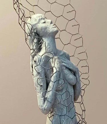Close up of a female figure, leaning back with eyes closed, surrounded by a wire netting enclosure