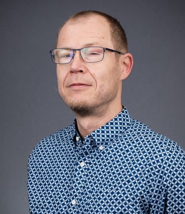 a man in a blue shirt and glasses