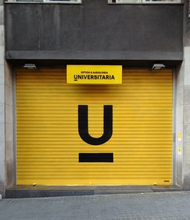 Graffiti en persiana, cierre metálico de Óptica Universitaria, Barcelona