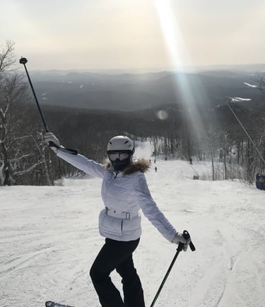 Female skier in a white jacket and helmet posing on a snowy mountain ski  resort Lake Louise Canada