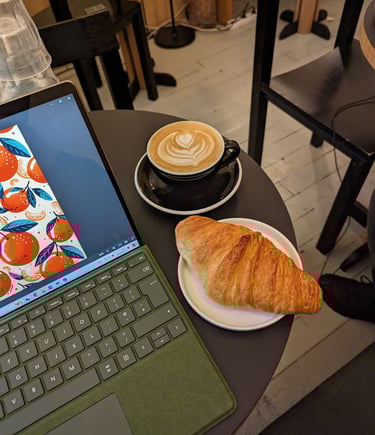 a laptop computer sitting on a table with a cup of coffee